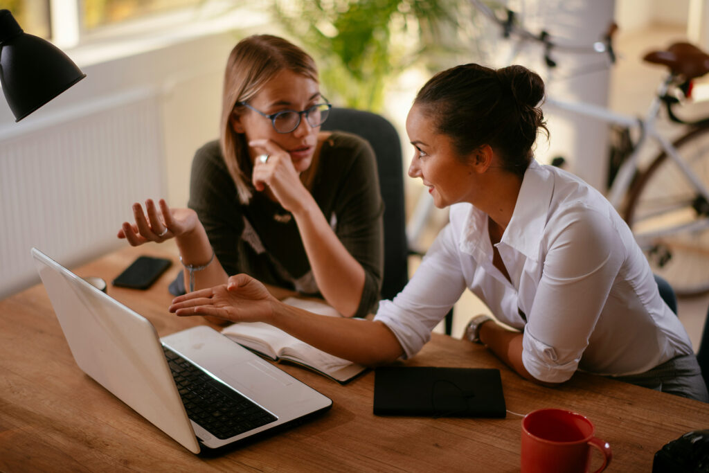 duas mulheres conversando no escritório representando uma one on one