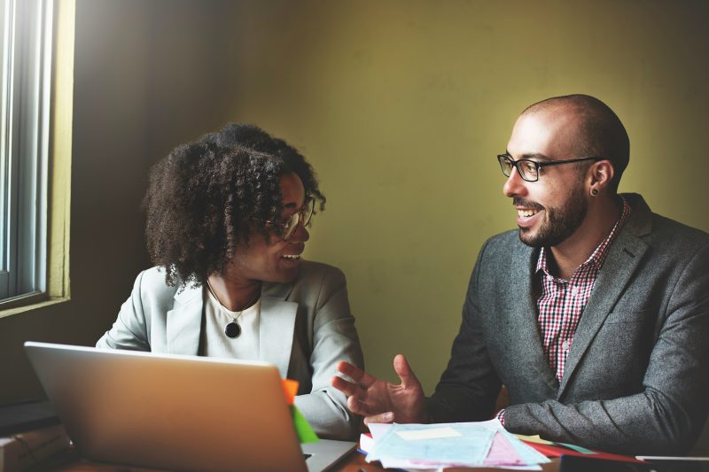 Gestor e colaboradora conversando sobre feedback durante reunião de trabalho